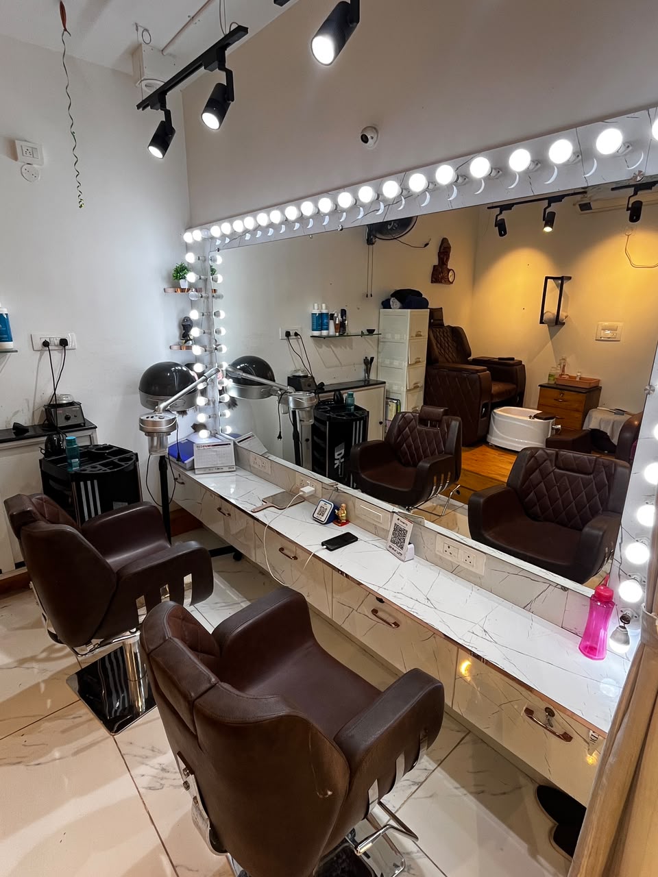 Makeup vanity with bulb-lit mirror at Signature Beauty Lounge