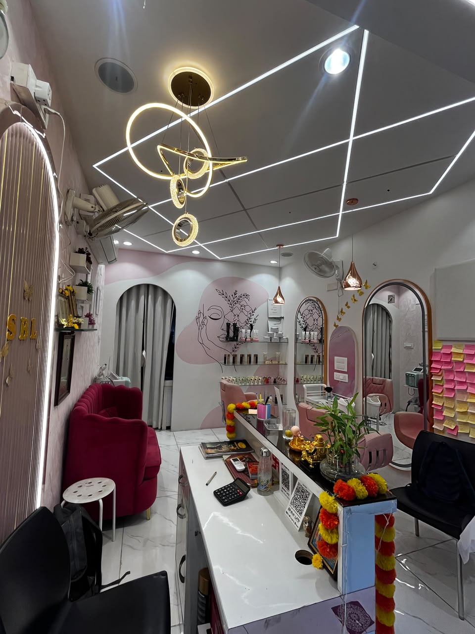 Interior of Signature Beauty Lounge with pink styling chairs and line-art wall mural